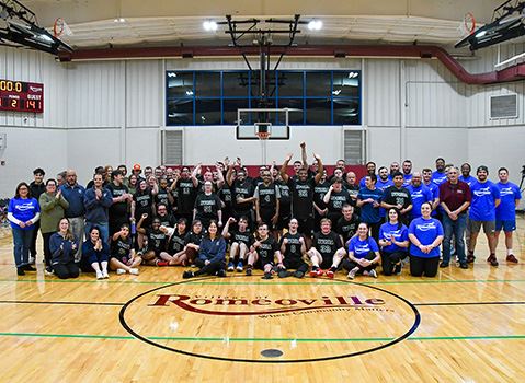 People pose for photo on basketball court