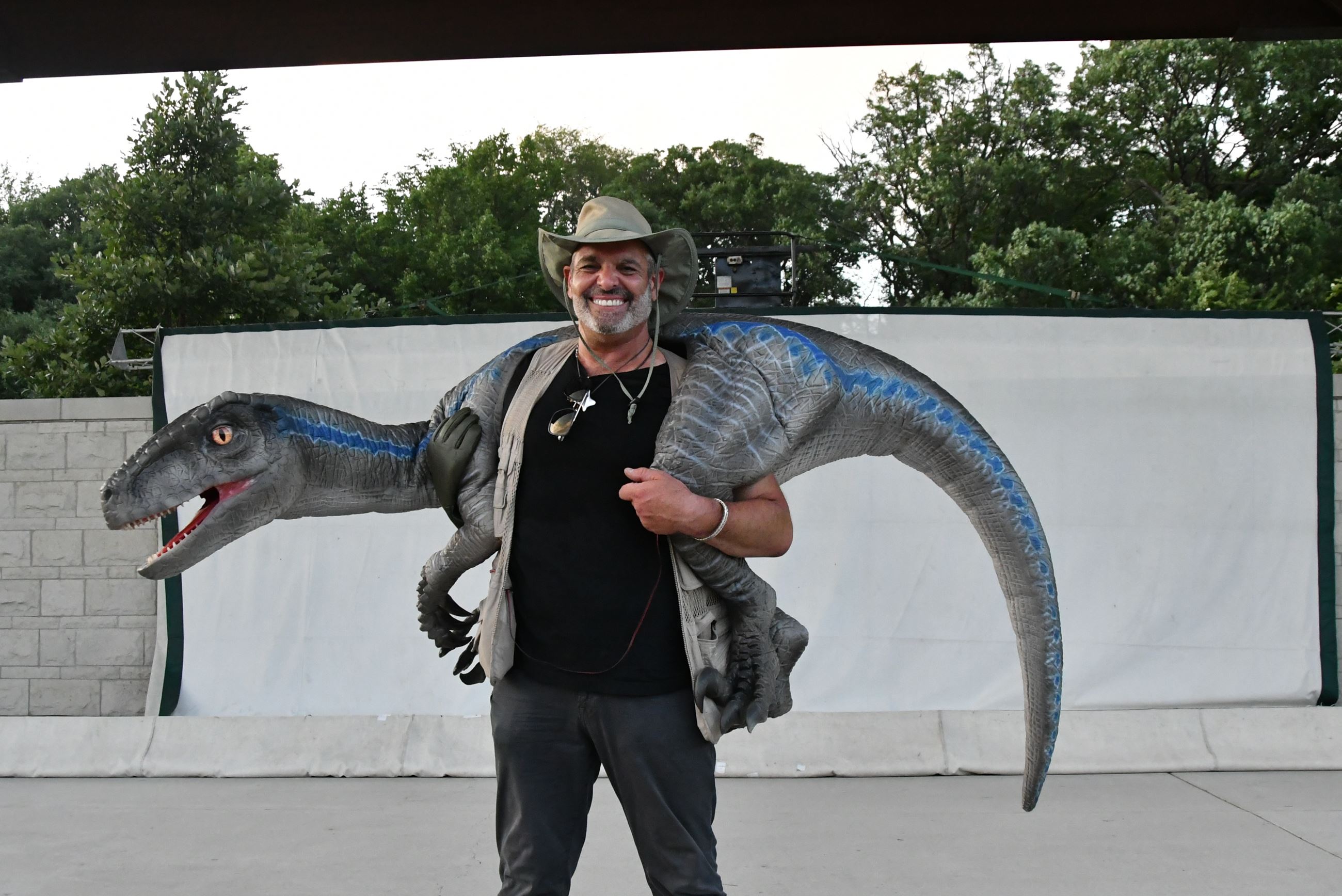 Man holding up a velociraptor character for childrens performance. 