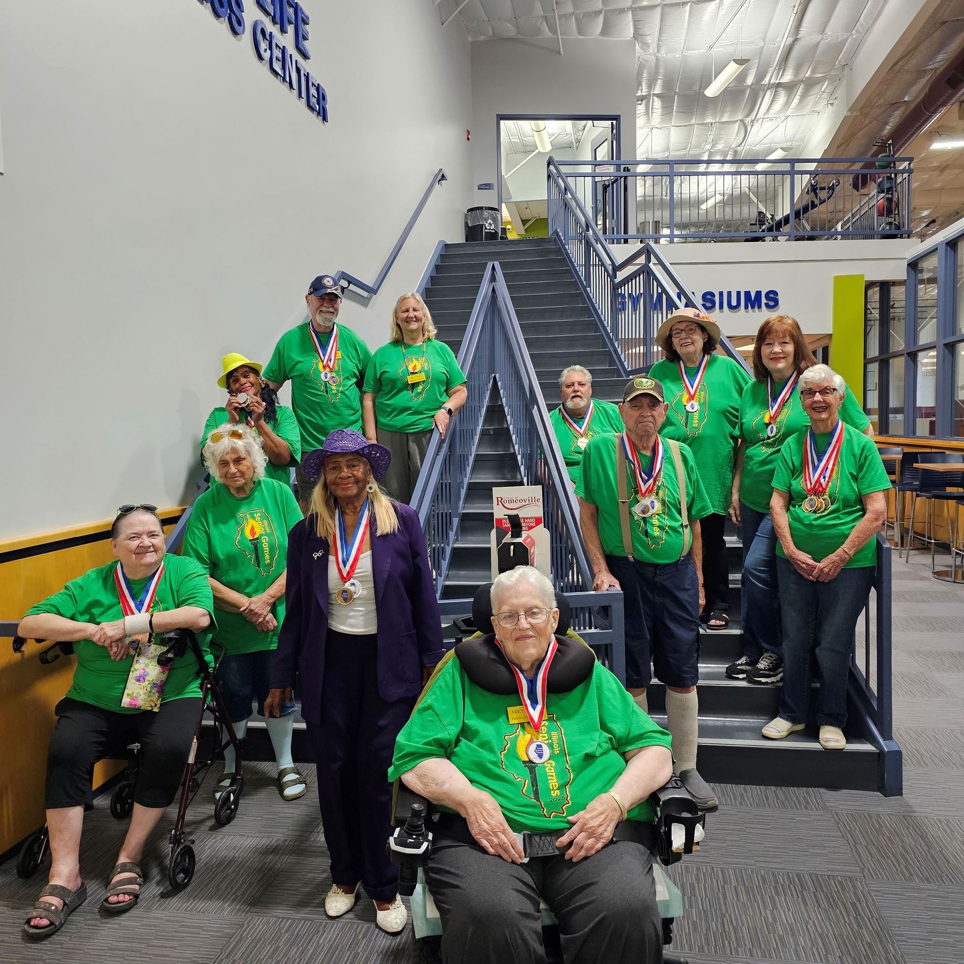 Romeoville Gold Age Club group in matching shirts wearing medals. 